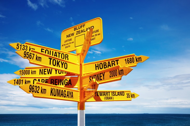a signpost in Bluff showing directions of places around the world