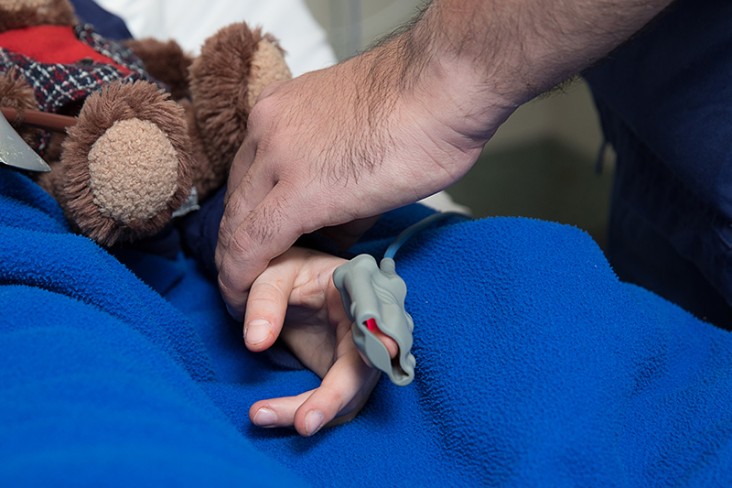 a child with teddy getting checked by a doctor