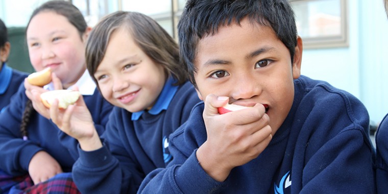 School kids eating fresh fruit