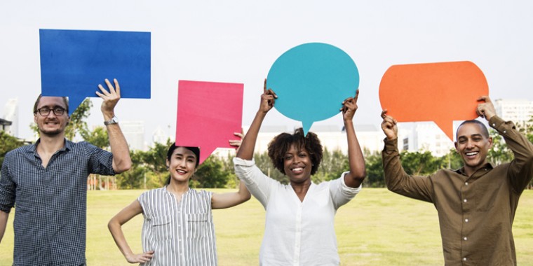 People holding up speech mark signs