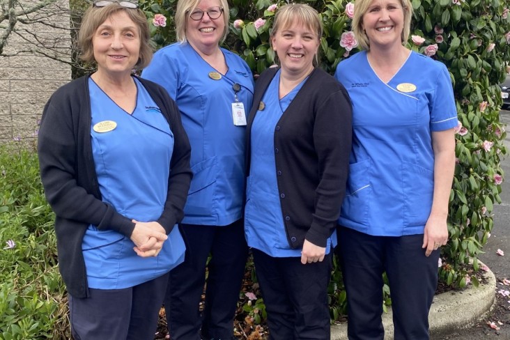 Four nurses in a group smiling