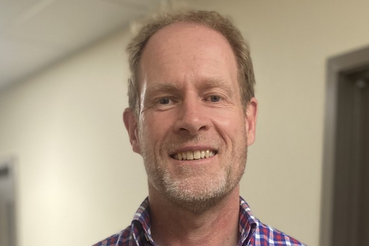A man in a corridor smiling