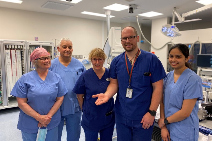 Medical team photographed together with a Cardiologist holding a Micra leadless pacemaker in his hand.