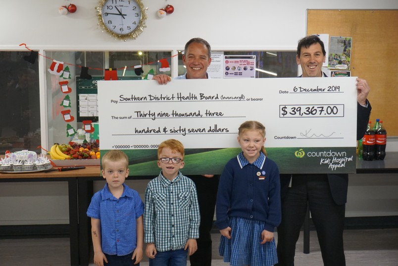 Countdown representative and kid ambassador with countdown donation cheque