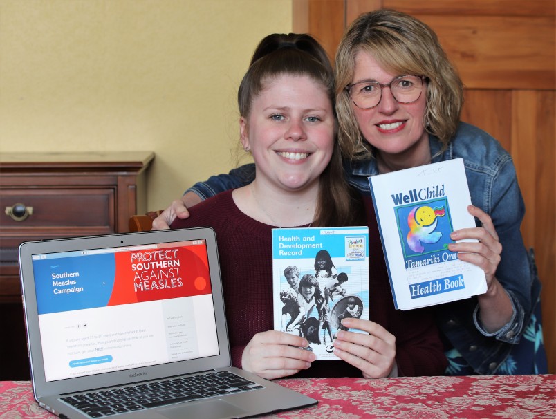 Eirwen Mitchell and daughter Samantha Tulett hunt out old paper vaccination records to upload.