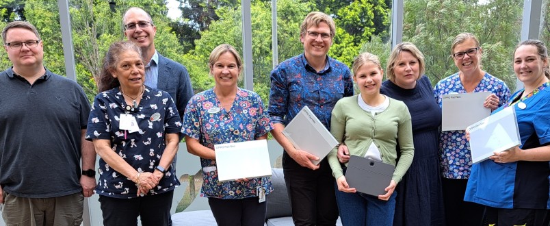 The Bradshaw family with healthcare staff holding the computer tablets that have been donated.