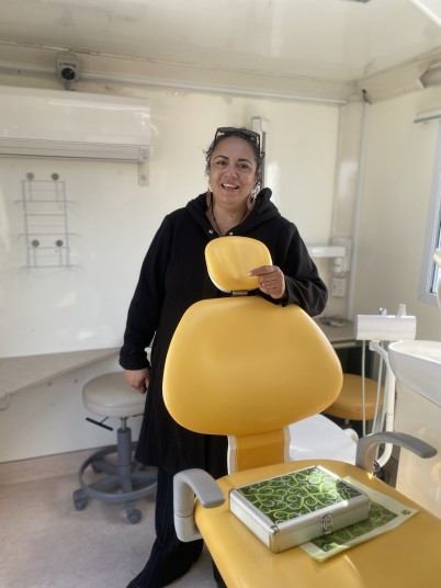 Dr ManuAroha Walker stands next to a dental chair